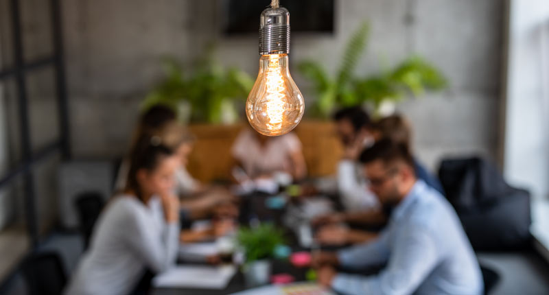 image with bulb in the foreground visible in a meeting room