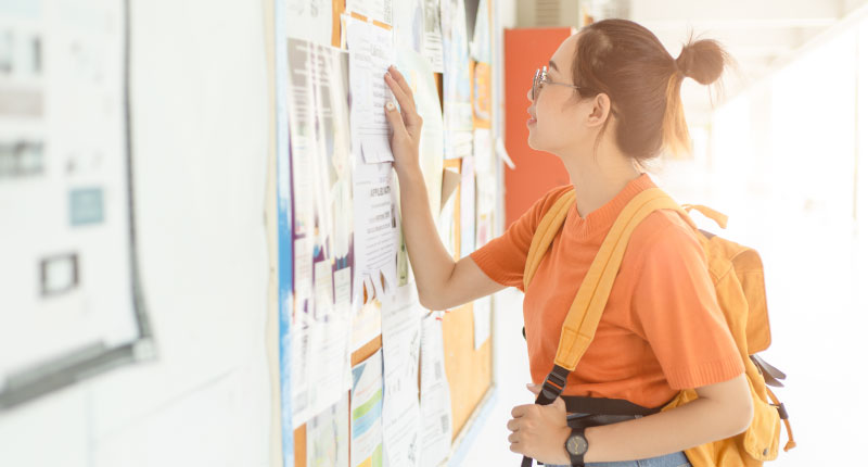 young woman looking for job on the post board