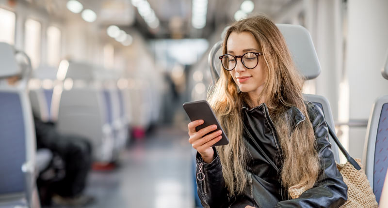 A woman worker uses a mobile to work during travel