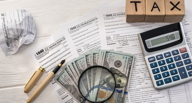 Tax form with dollar, calculator and wooden cubes