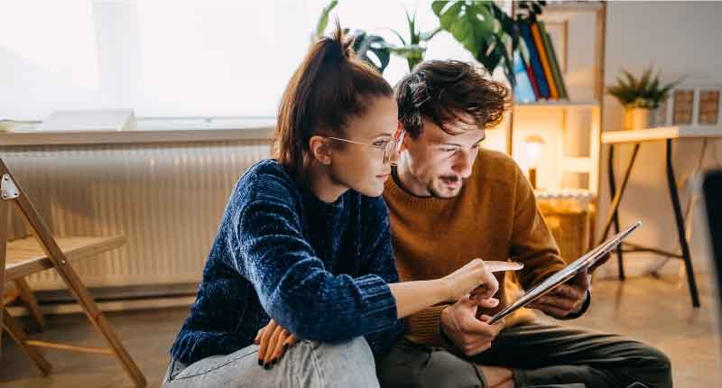 man and woman looking at tablet screen and discussing