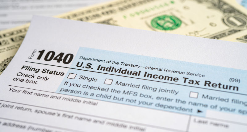 Tax Return form 1040 with USA America flag and dollar banknote